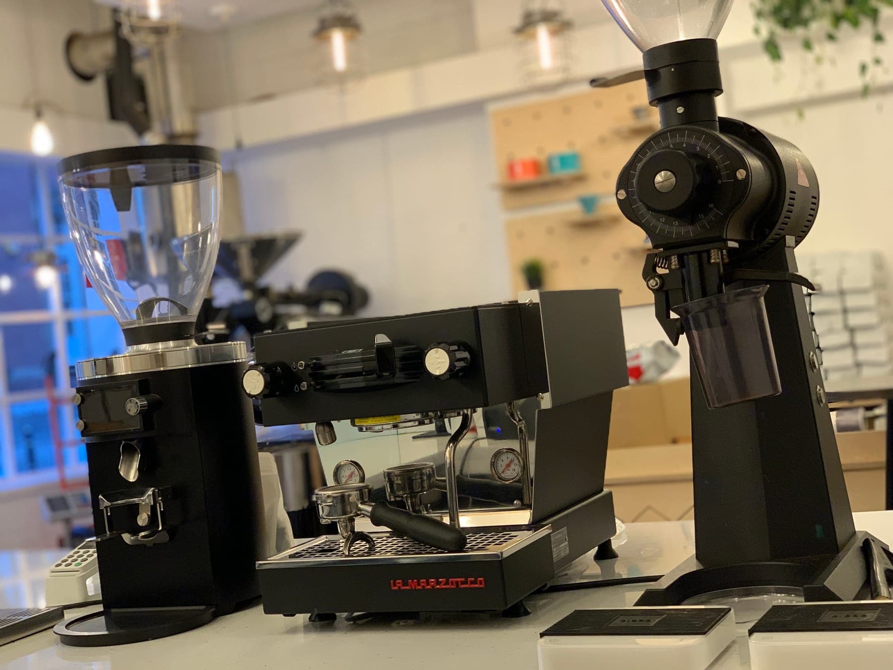 An espresso machine and grinders set up on a brew bar